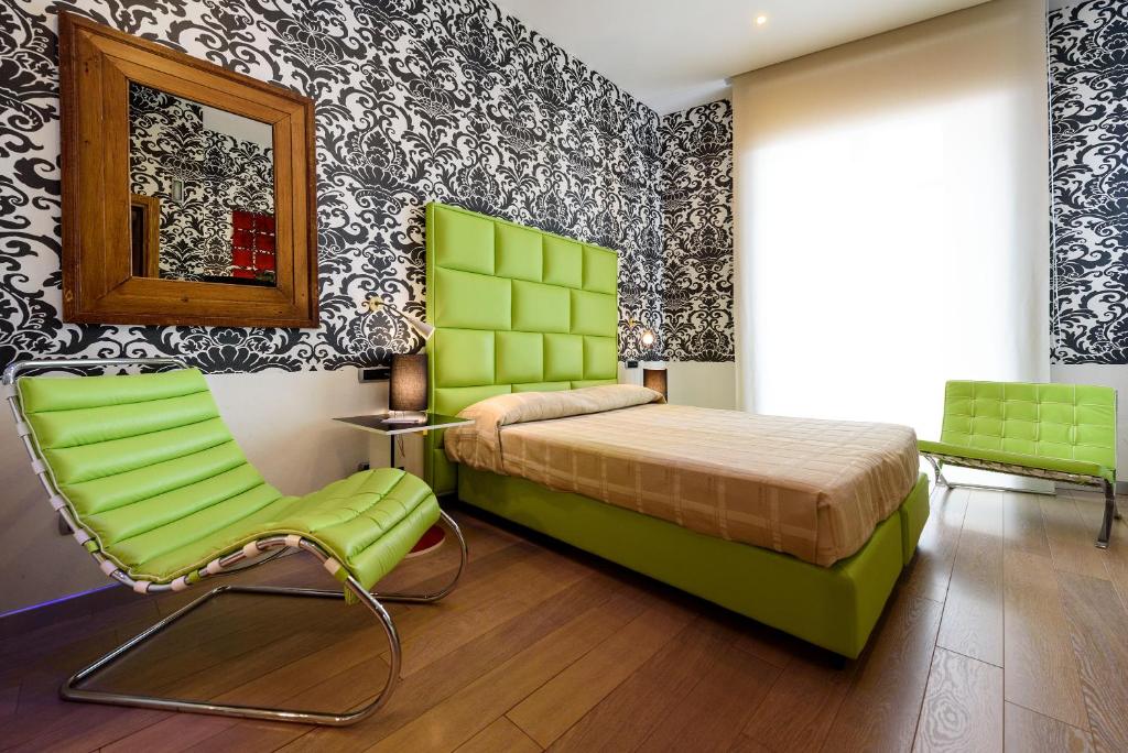 a bedroom with a green bed and a chair at Palazzo Ferraioli - Hotel & Wellness in Atrani