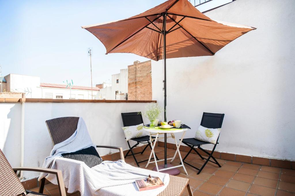 a patio with a table and an umbrella at Feelathome Mozart Apartments in Barcelona