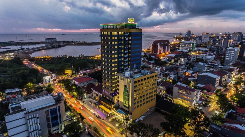 un edificio alto en una ciudad por la noche en Arthama Hotels Makassar en Makassar