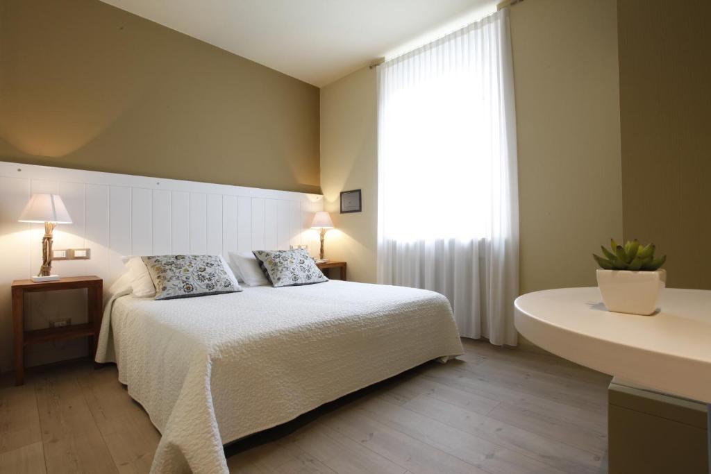 a bedroom with a bed and a large window at Hotel Liberty in Levico Terme