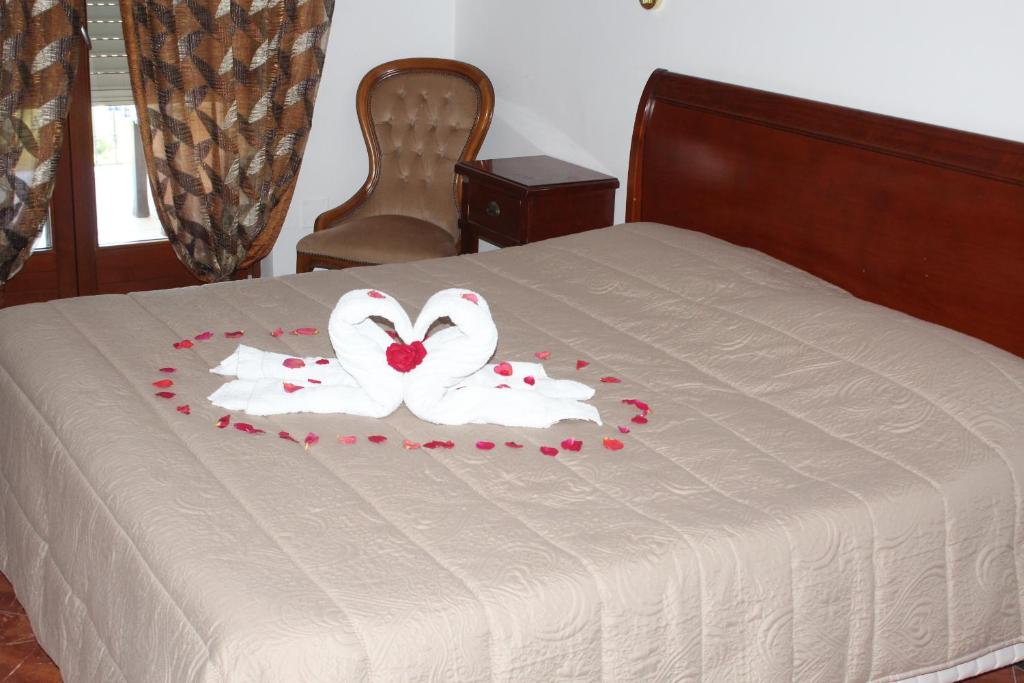 two white swans on a bed with roses on it at Residence Hotel Torresilvana in Vieste
