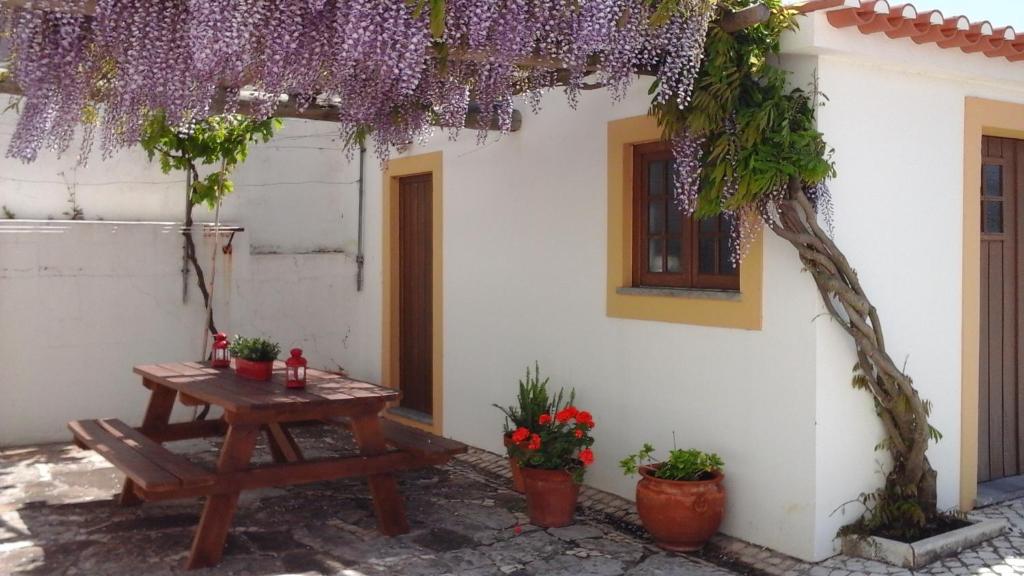 a picnic table in the courtyard of a house with purple flowers at Pátio Mateus in Areia Branca