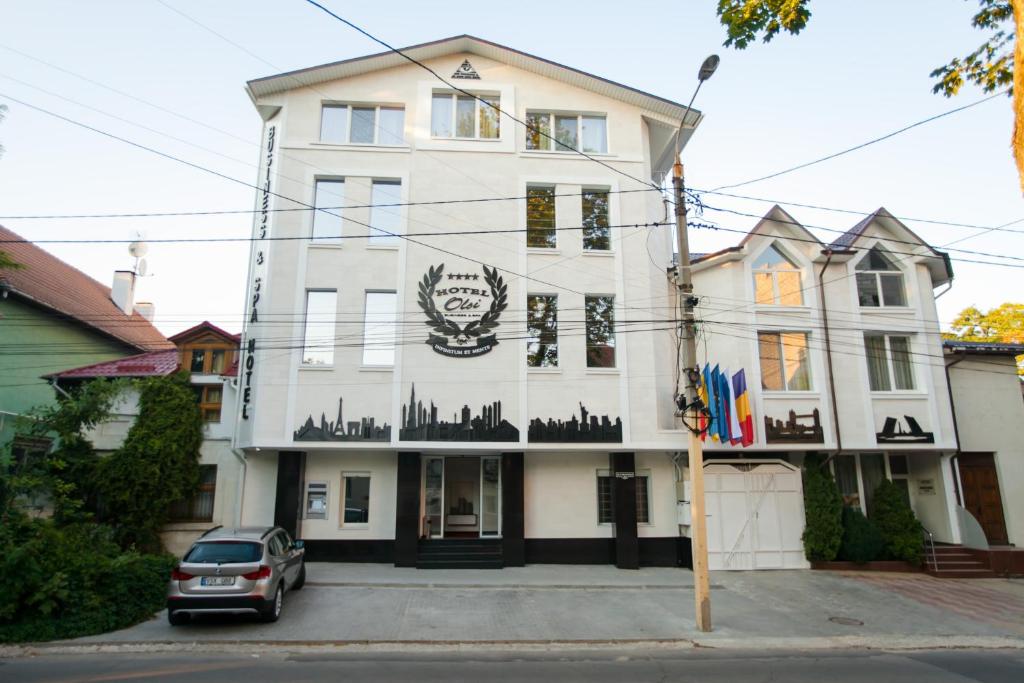un edificio blanco con un cartel. en Bed & Breakfast Olsi, en Chişinău