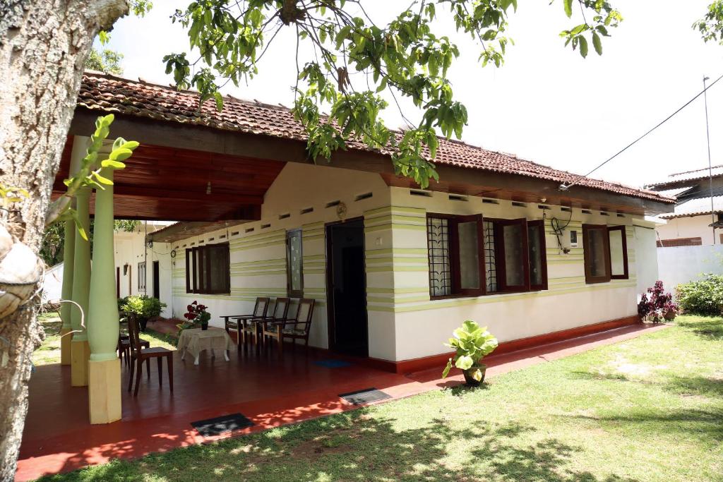 een huis met een tafel en stoelen ervoor bij Surf reef guest house in Mirissa