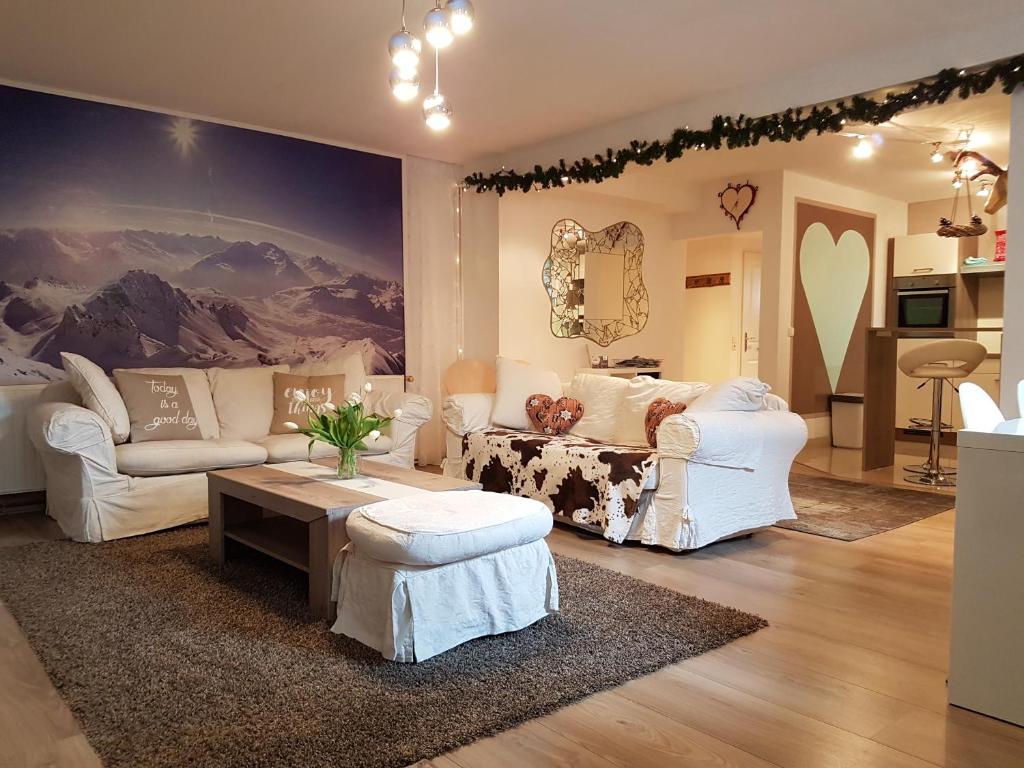 ニーダーンジルにあるHaus Valderの白い家具と壁画が備わるリビングルーム