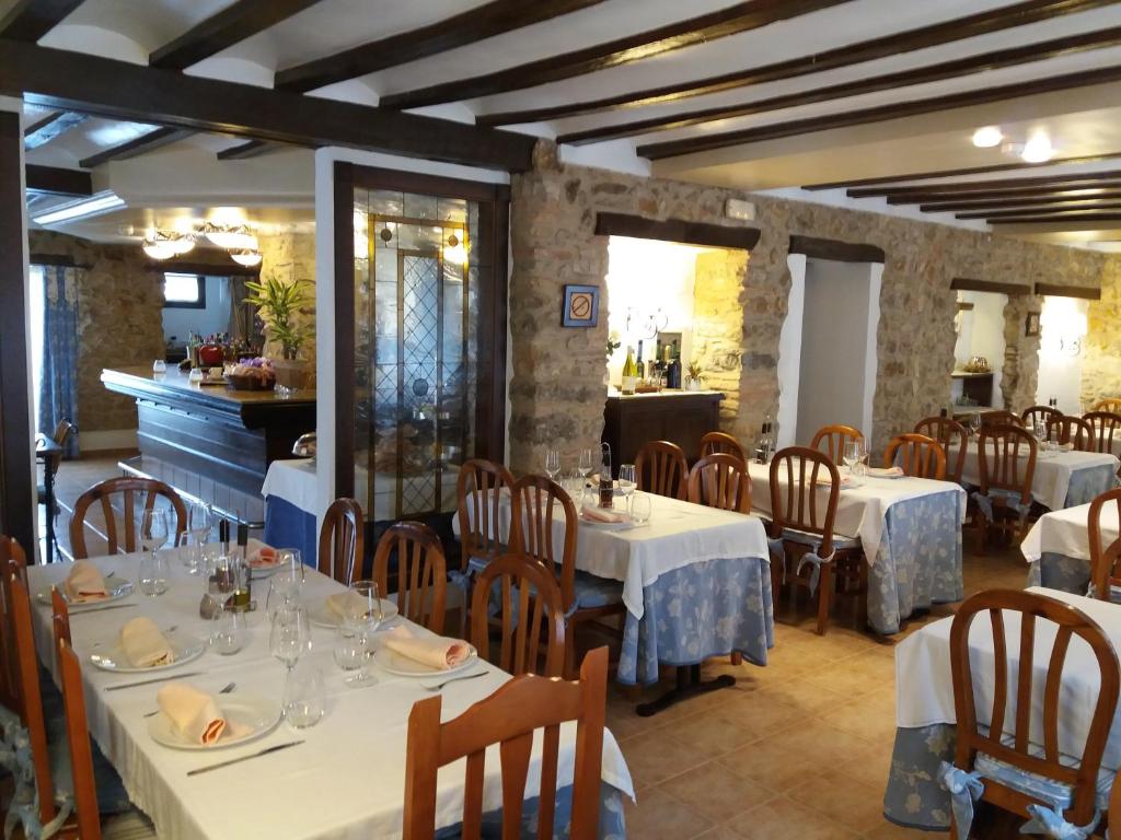 un restaurante con mesas y sillas con manteles blancos en Casa Banys L'Avellà, en L’Avellà