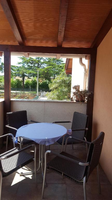 niebieski stół i krzesła w pokoju z oknem w obiekcie Apartmani Viktorija w Fažanie