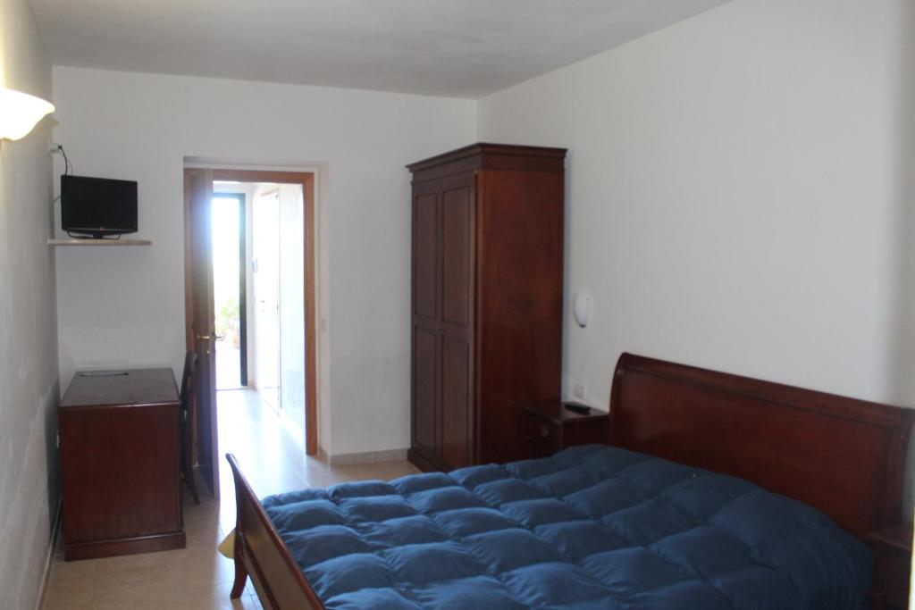 a bedroom with a blue bed and a wooden cabinet at Residence Hotel Torresilvana in Vieste