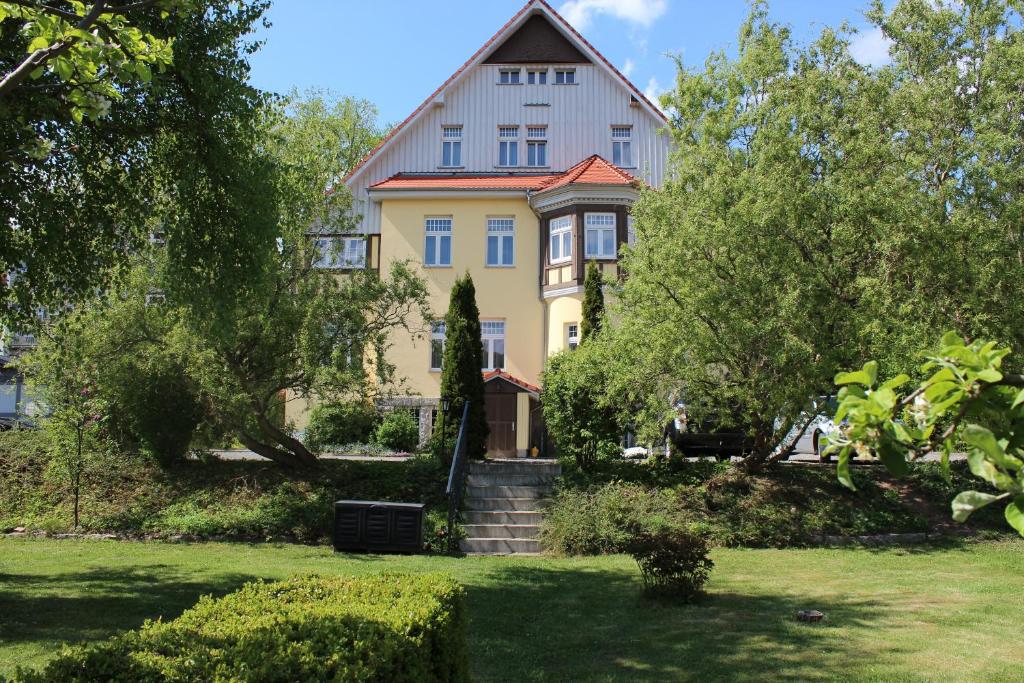 a large yellow house with a large yard at Villa Jagdhaus in Wernigerode