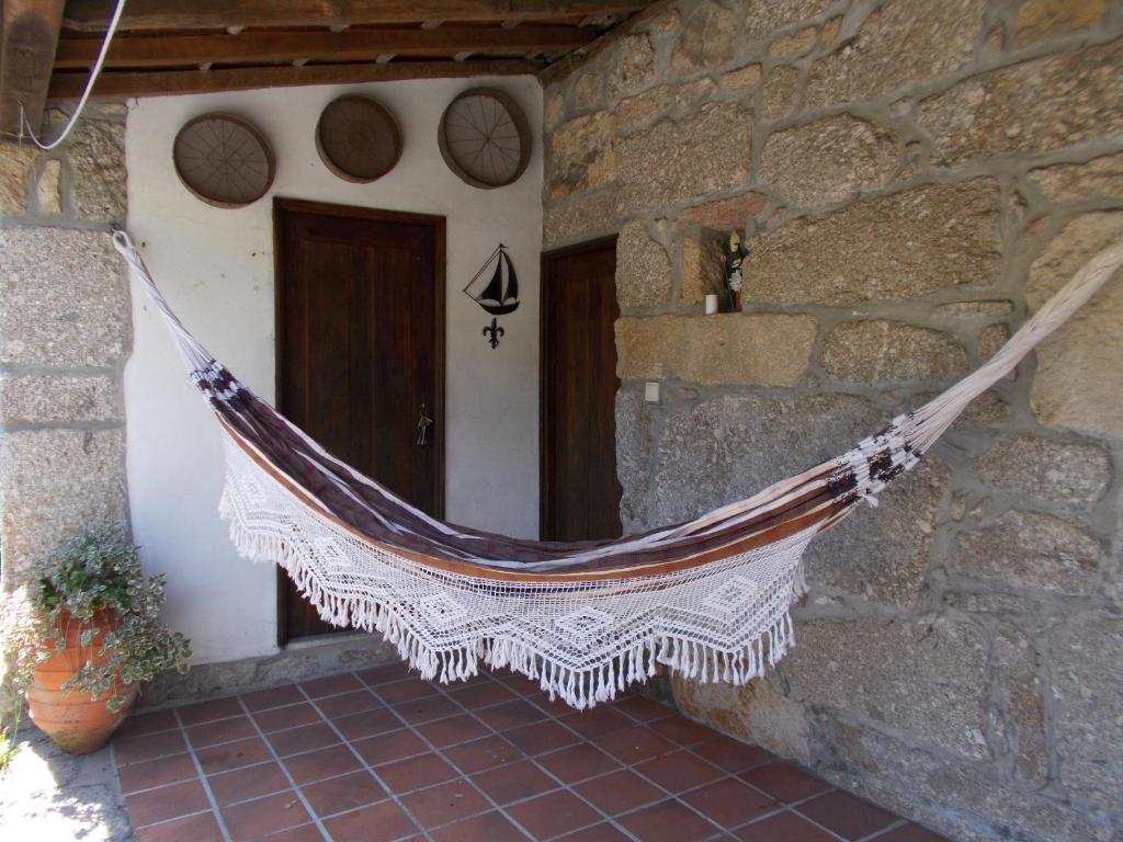 a hammock hanging from the outside of a building at Casa da Aldeia in Terras de Bouro