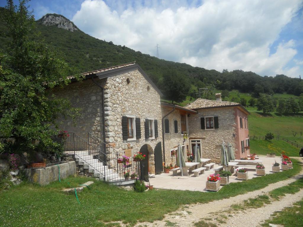 a stone building with stairs next to a mountain at Agriturismo Lusani in Caprino Veronese