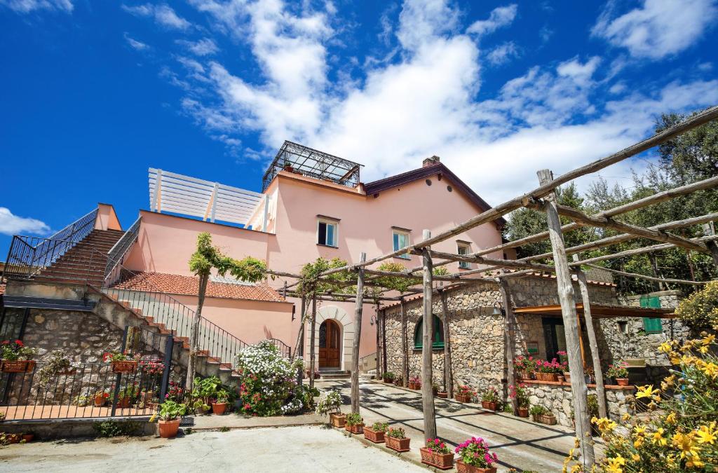 ヴィーコ・エクエンセにあるB&B Cassiopeaの階段と植物のある大きなピンクの家