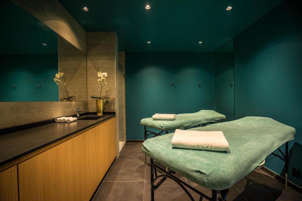 a barber shop with two green chairs and a counter at Best Western Plus Hostellerie Du Vallon in Trouville-sur-Mer