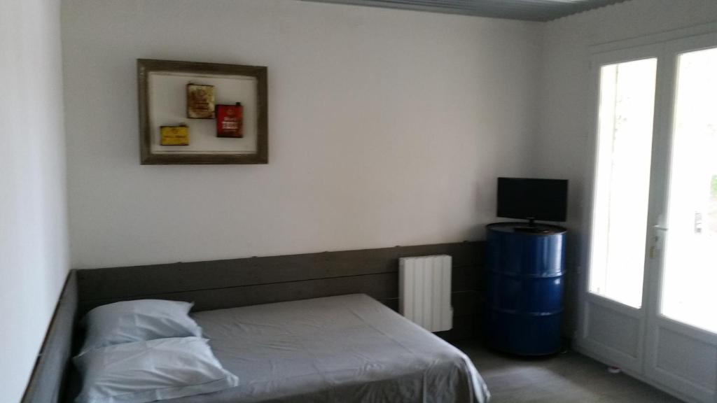 a bedroom with a bed and a television and a window at Leucateloc in Leucate-Plage