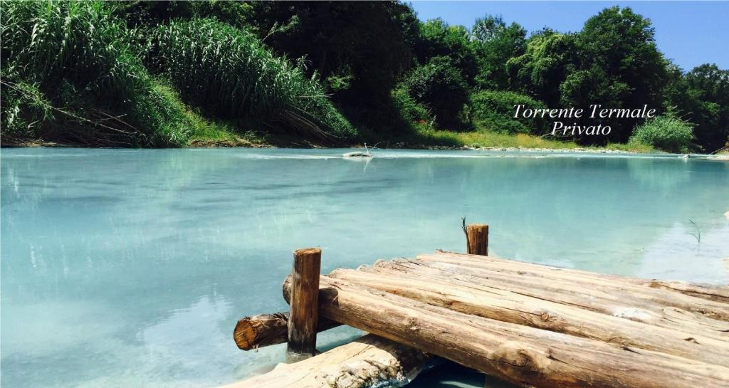 a body of water with a log in the foreground at B&B Le Cascatelle di Saturnia in Saturnia