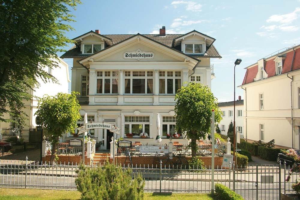 - un grand bâtiment blanc avec un restaurant en face dans l'établissement Schmiedehaus - Appartement, à Heringsdorf