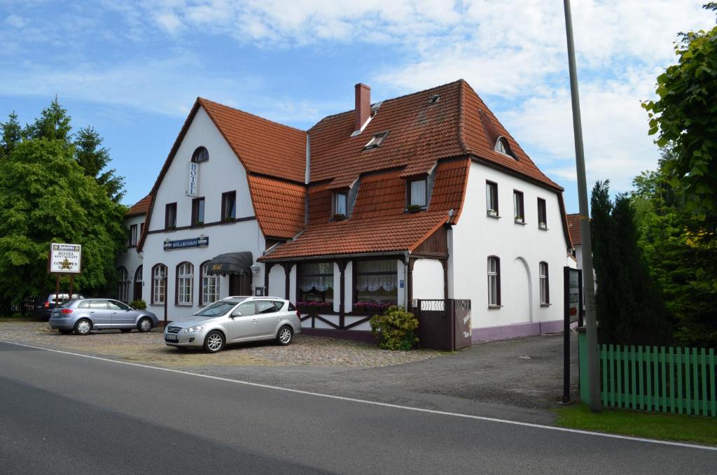 ein großes weißes Gebäude mit davor geparkt in der Unterkunft Hotel Zum goldenen Stern in Leibsch