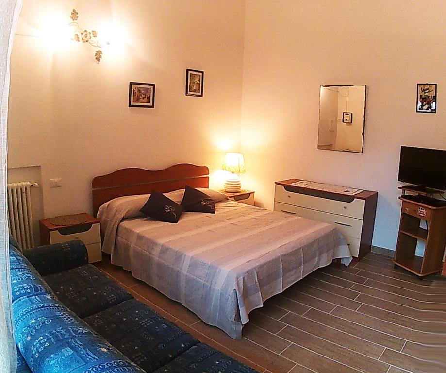 sypialnia z łóżkiem, telewizorem i kanapą w obiekcie La Mimosa w mieście Forte dei Marmi