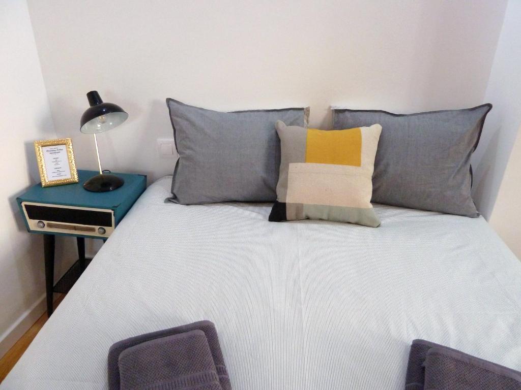 リスボンにあるDreaming Lisbon - Trigueiros Pateoのベッドルーム1室(青と黄色の枕が備わるベッド1台付)