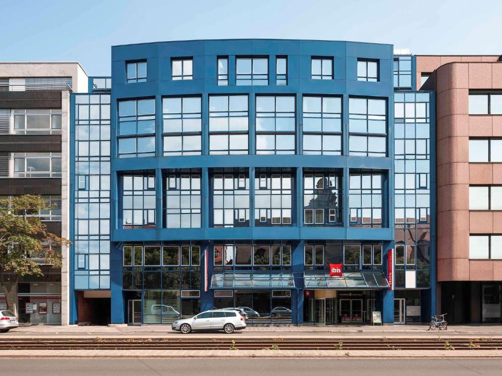 ein blaues Gebäude mit einem davor geparkt in der Unterkunft ibis Nürnberg Hauptbahnhof in Nürnberg