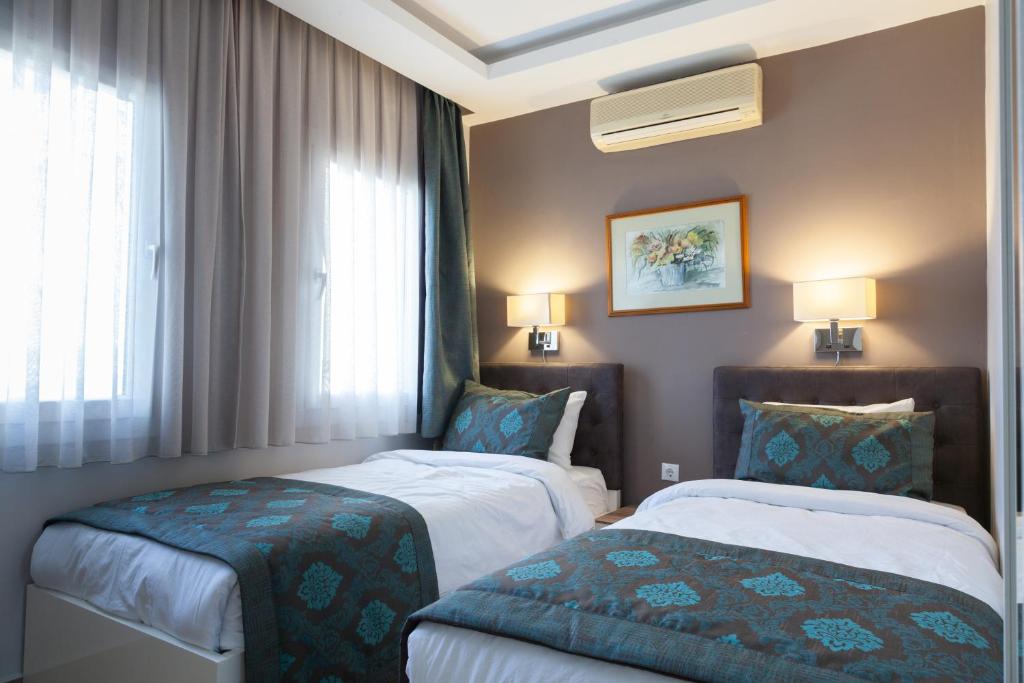Habitación de hotel con 2 camas y ventana en Sun Garden Apart Hotel en Yalıkavak