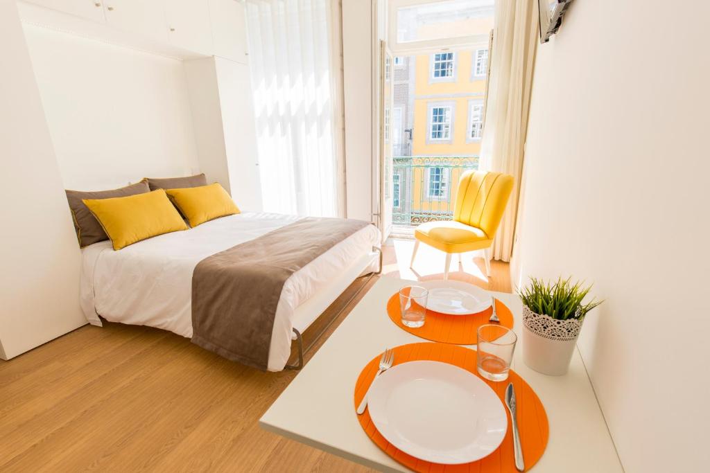 a bedroom with a bed and two tables in front of a window at Downtown Porto Mouzinho Studio Apts in Porto
