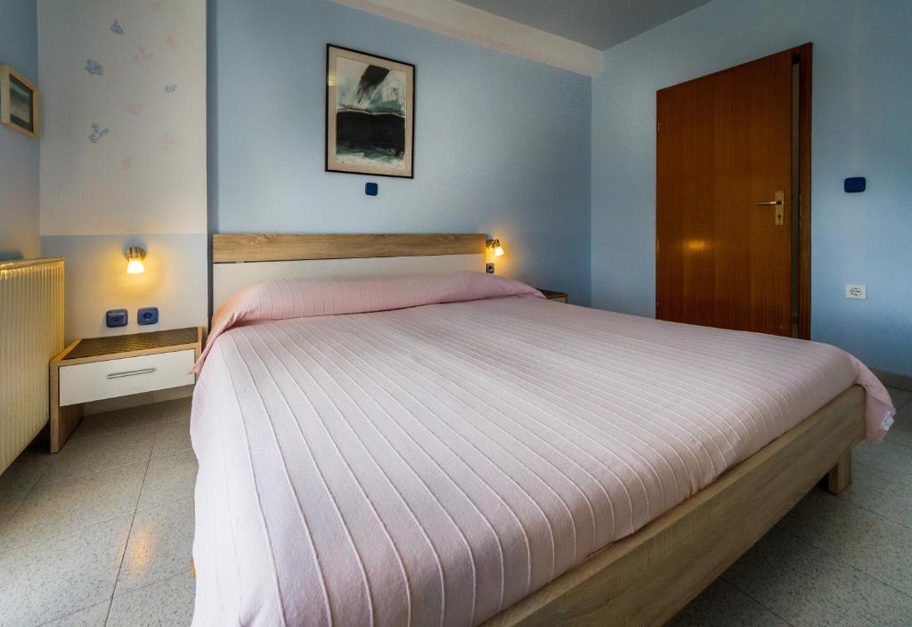 a bedroom with a large bed with pink sheets at Apartments Borghese in Pula