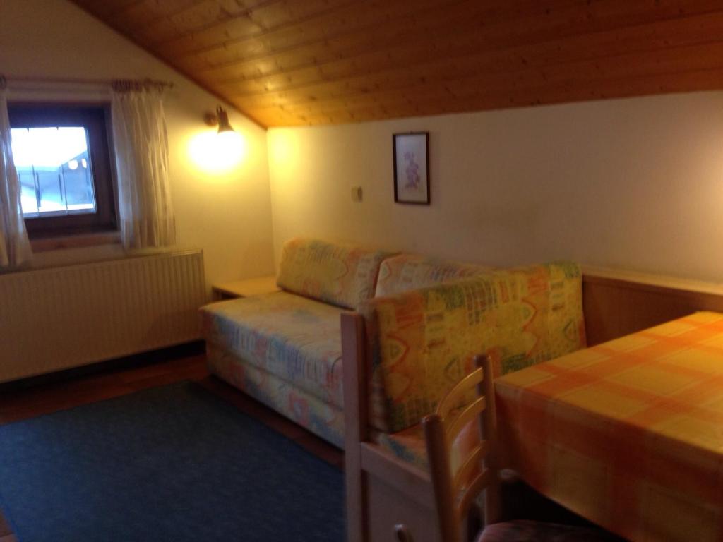 ein Wohnzimmer mit einem Sofa und einem Bett in der Unterkunft Schuster Emma in Olang