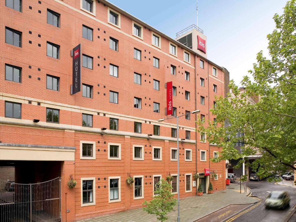 a large red brick building on a city street at Ibis Sheffield City in Sheffield