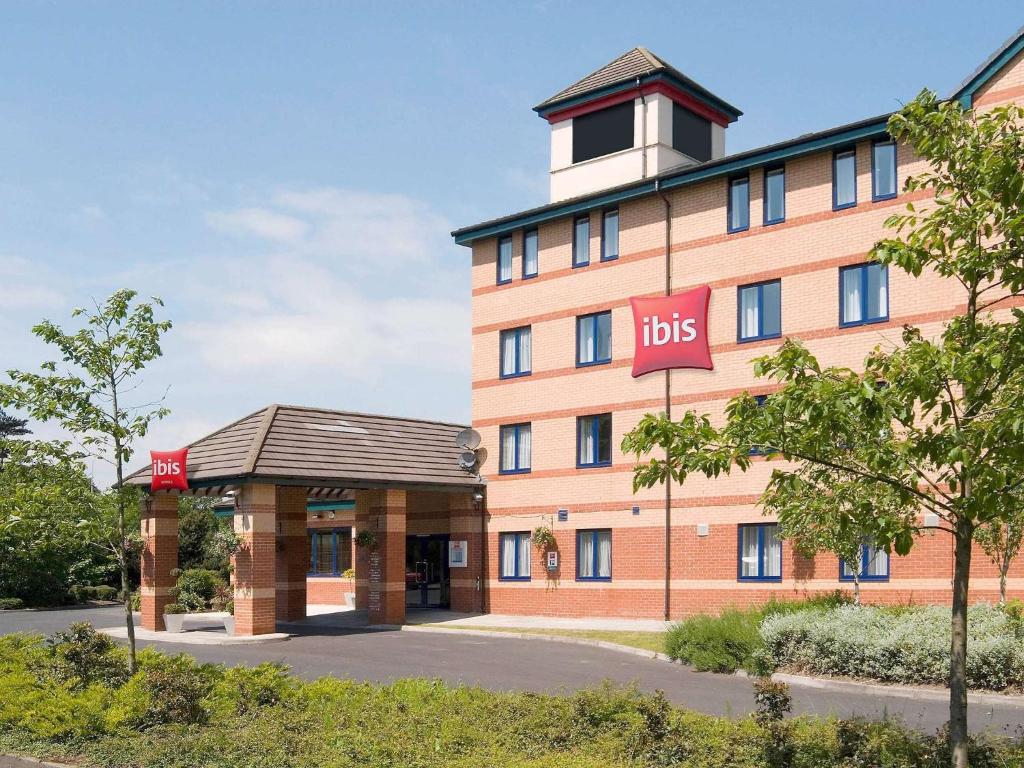 a large orange building with a bus stop in front of it at ibis Preston North in Preston