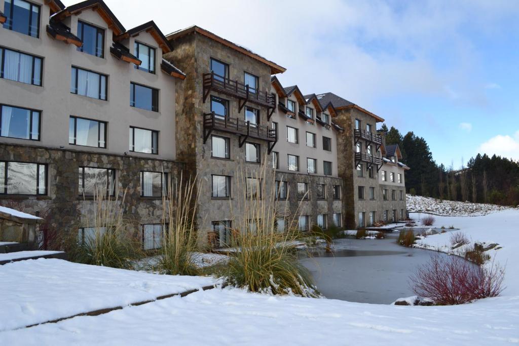 a row of apartment buildings in the snow at Loi Suites Chapelco Hotel in San Martín de los Andes
