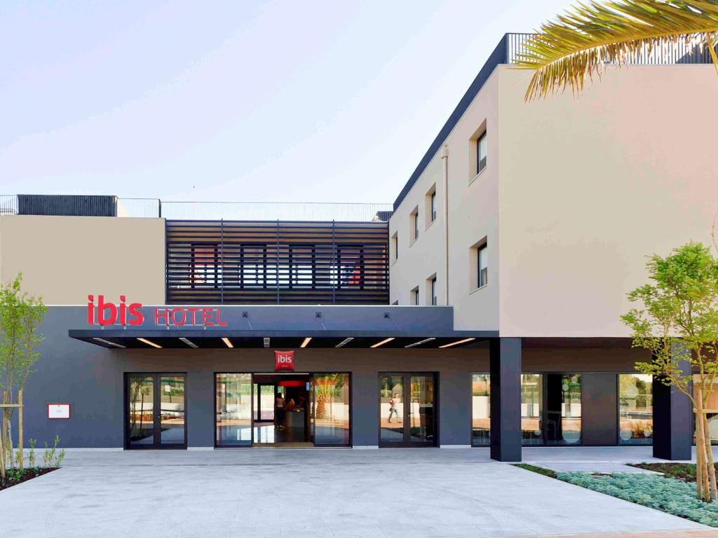 a building with a lionsroth sign on the front of it at Hotel Ibis Lisboa Sintra in Sintra