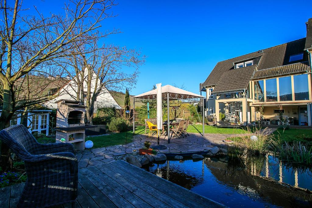 einen Hinterhof mit einem Teich und einem Haus in der Unterkunft Ferienwohnung Laurent in Pünderich