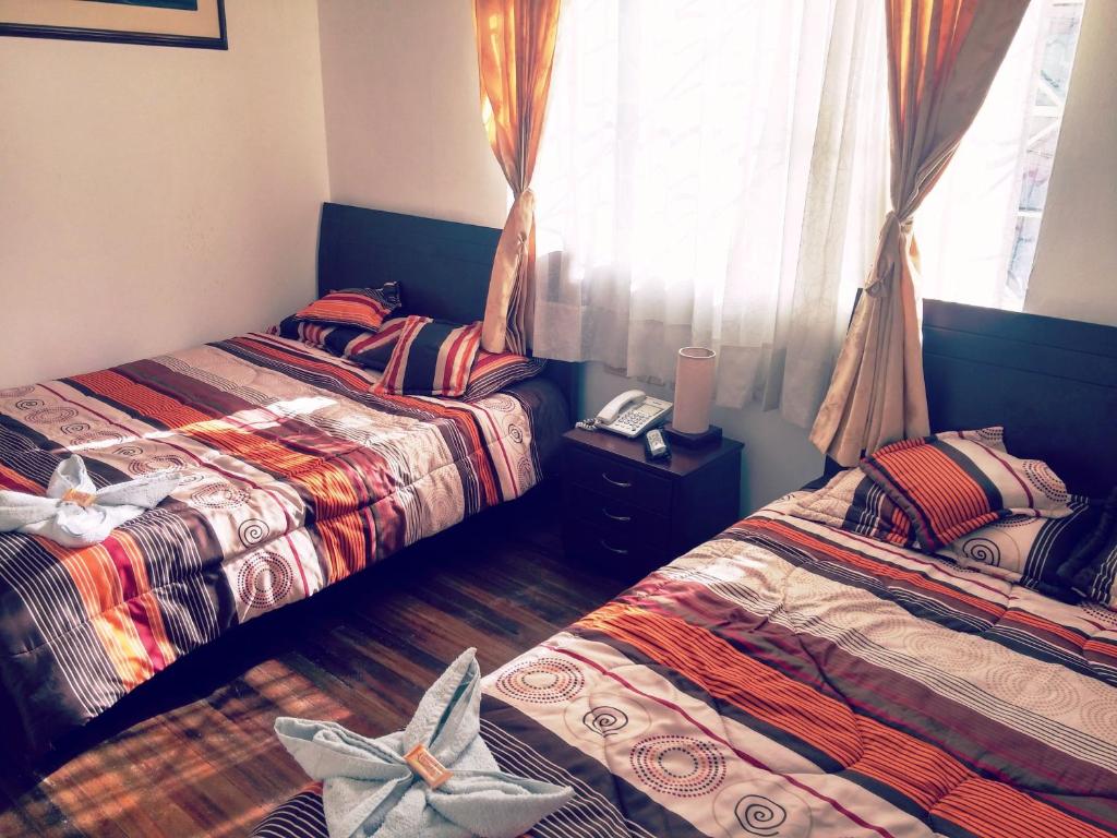 1 Schlafzimmer mit 2 Betten und einem Fenster in der Unterkunft Hotel Andino Real in Bogotá