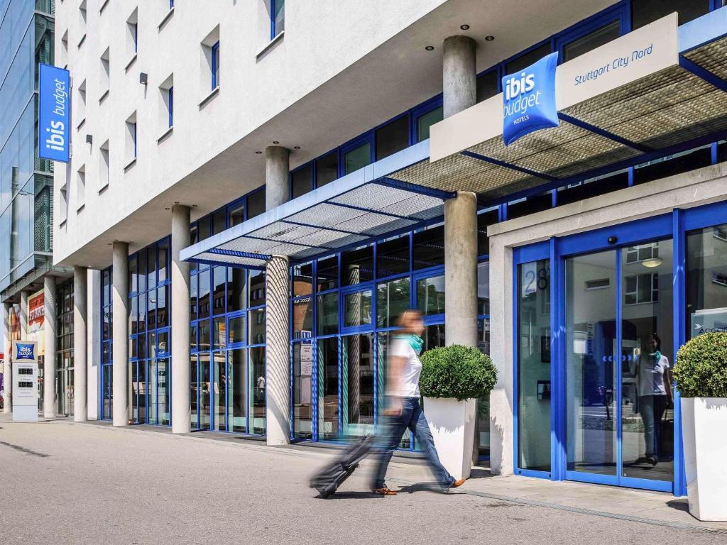 a man walking in front of a building at ibis budget Stuttgart City Nord in Stuttgart