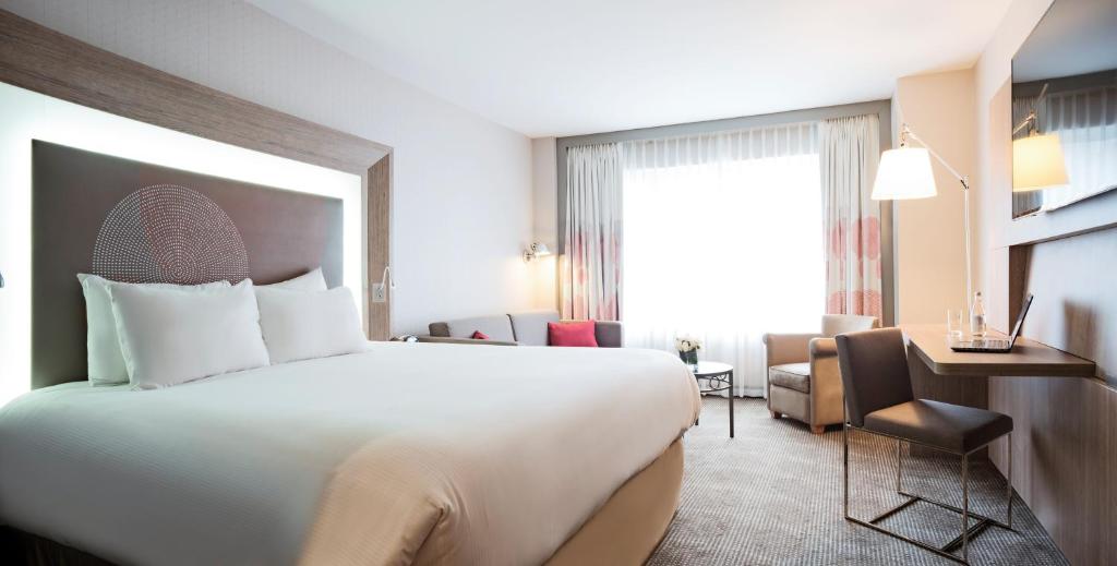 
a hotel room with a large bed and a large window at Novotel Montreal Center in Montreal
