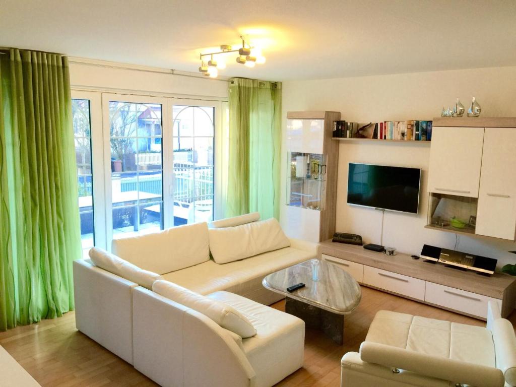 a living room with a white couch and a tv at Symphonie-Villa am See - Musikerviertel in Konstanz