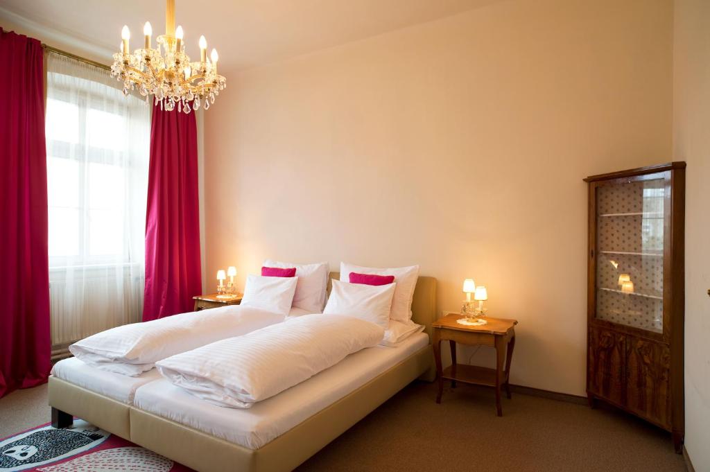 a bedroom with a bed with red curtains and a chandelier at Fink Low Budget Rooms in Vienna