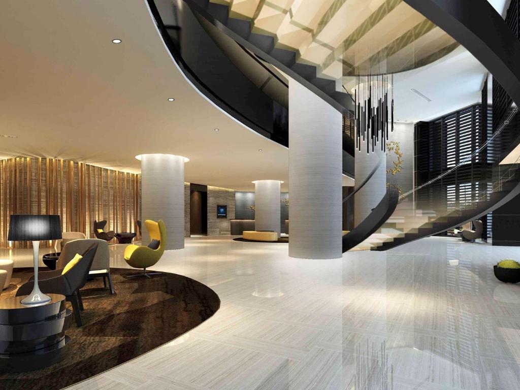 ein Wohnzimmer mit einer Treppe und eine Lobby in der Unterkunft Grand Mercure Dongguan Humen in Dongguan