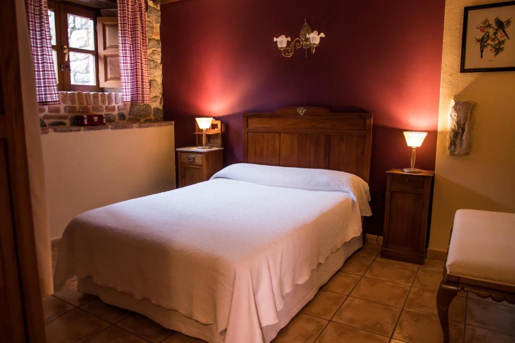 a bedroom with a white bed in a room at Viviendas Rurales Las Fontanias in Cóbreces