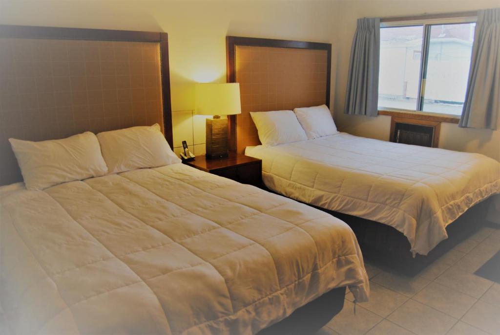 een hotelkamer met 2 bedden en een raam bij Edgewater Inn in Sylvan Lake