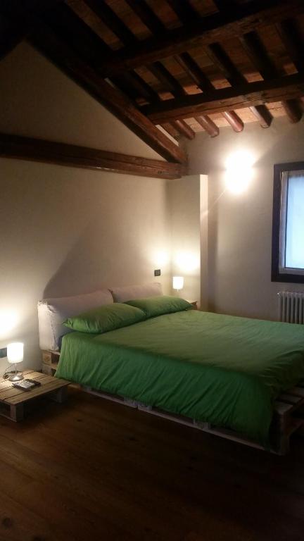 Un dormitorio con una cama verde y una ventana en Alloggio Il Giuggiolo, en Bassano del Grappa
