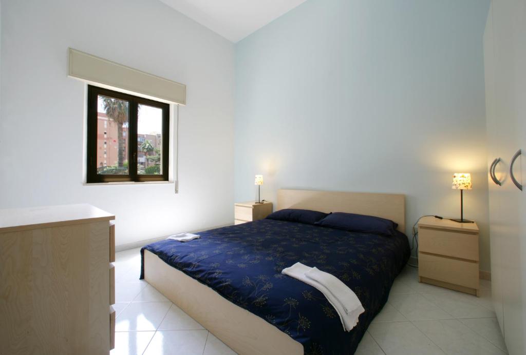 a bedroom with a large bed and a window at Novecento in Trapani