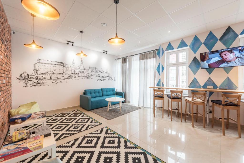 克拉科夫的住宿－金吉爾公寓式青旅，客厅配有蓝色的沙发和桌子