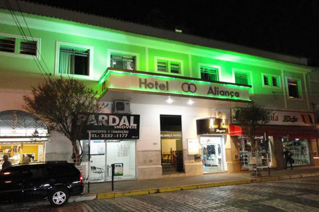 a building with green lights on the front of it at Hotel Aliança in São Lourenço