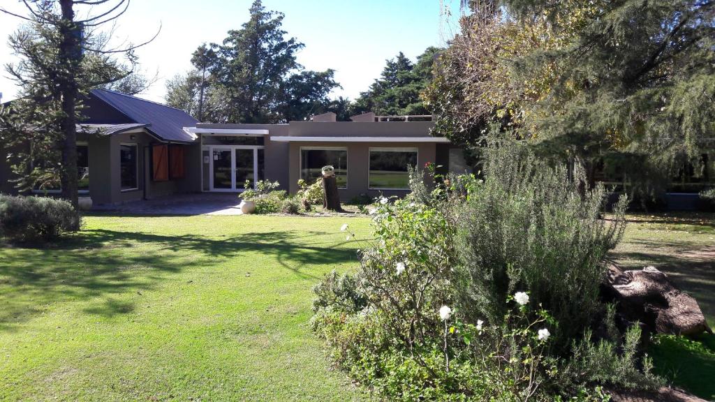 a house with a garden in front of it at Hotel de Campo Posada la Esperanza in Río Cuarto