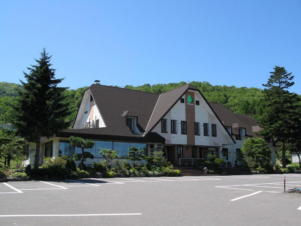 a large building with a parking lot in front of it at Pension Ohno in Sobetsu