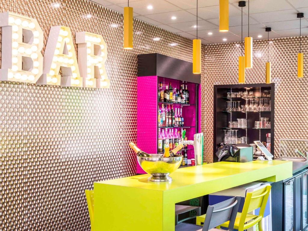 a bar with a yellow table and yellow chairs at ibis Styles Antony Paris Sud in Antony