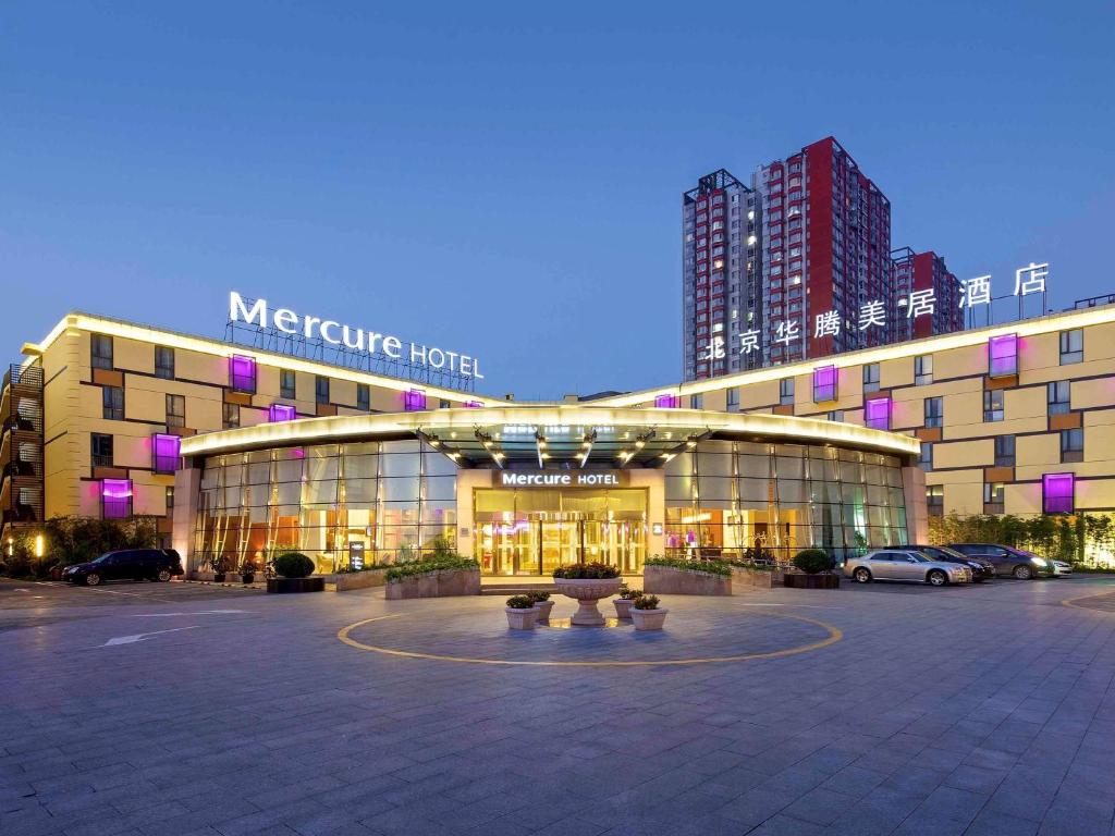 a large building in a parking lot at night at Mercure Beijing Downtown in Beijing