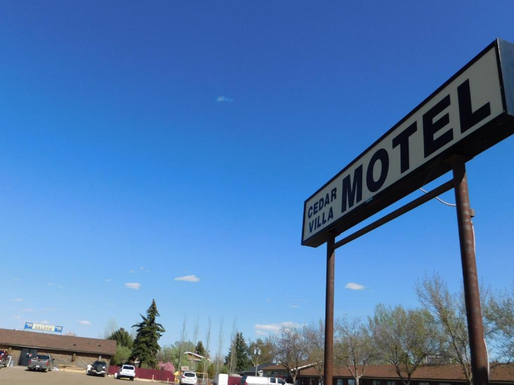 un letrero de la calle frente a un estacionamiento en Cedar Villa Motel, en Foremost